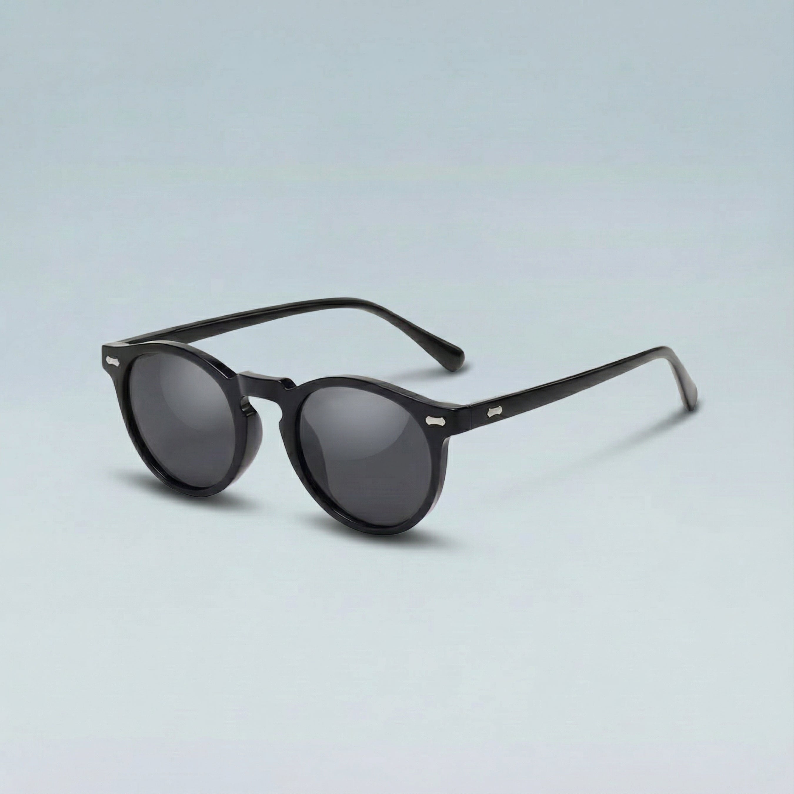 Black sunglasses with dark lenses on a light gray background