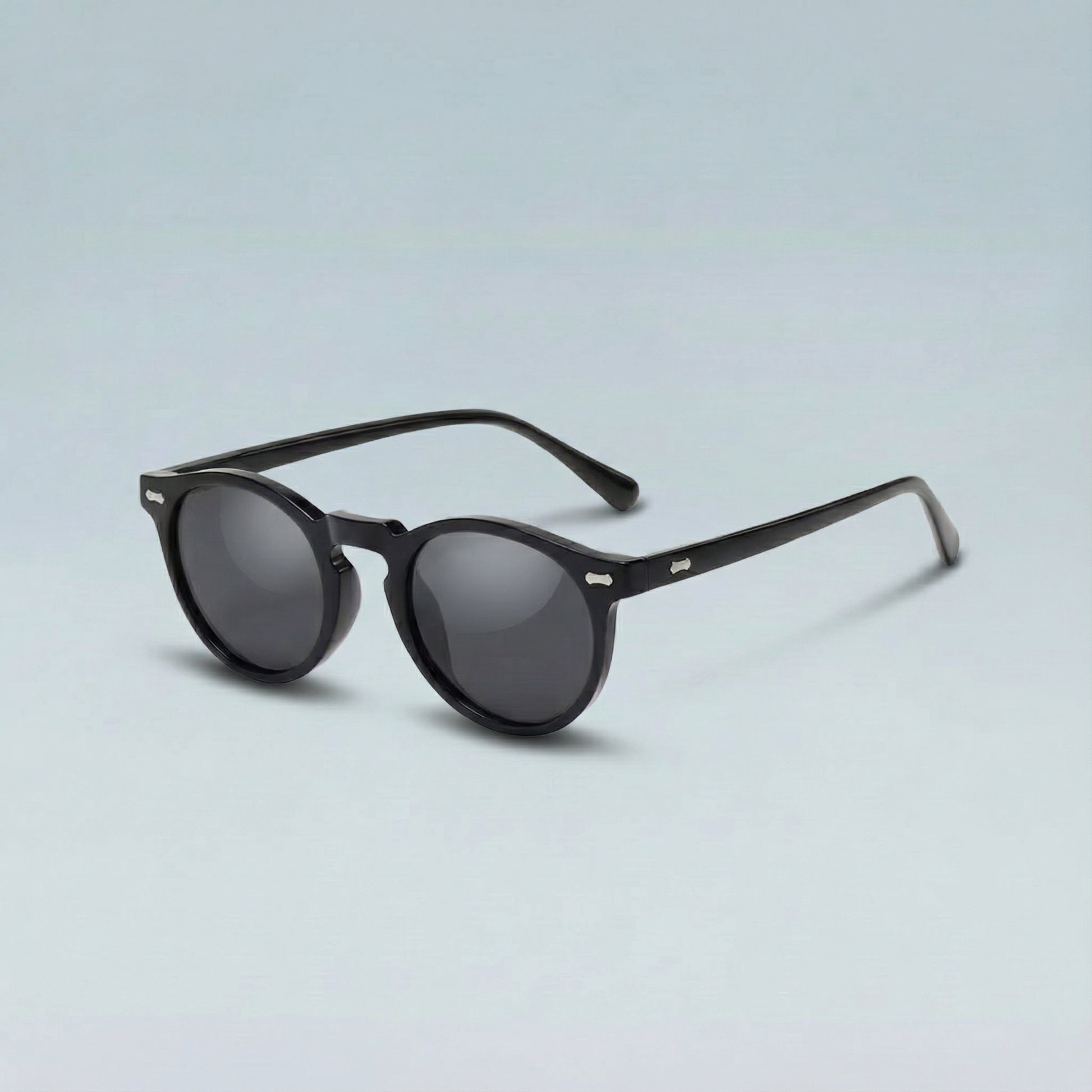 Black sunglasses with dark lenses on a light gray background