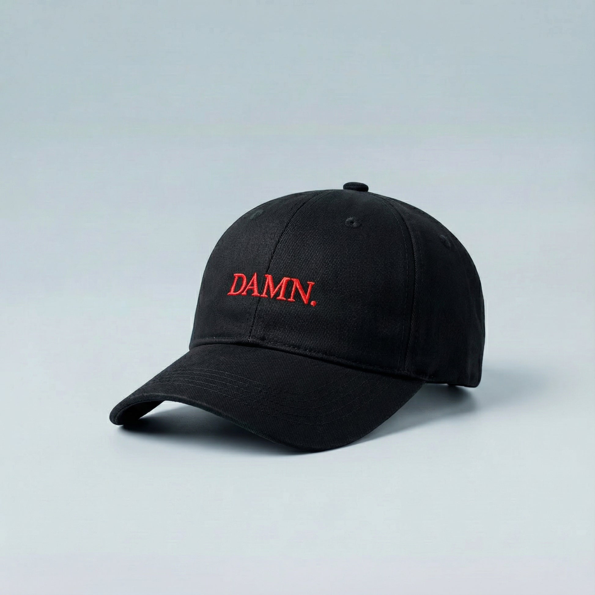 Minimalist black cap featuring the bold “DAMN.” red embroidery, delivering a refined urban attitude. A versatile accessory for those who appreciate understated style with strong personality.