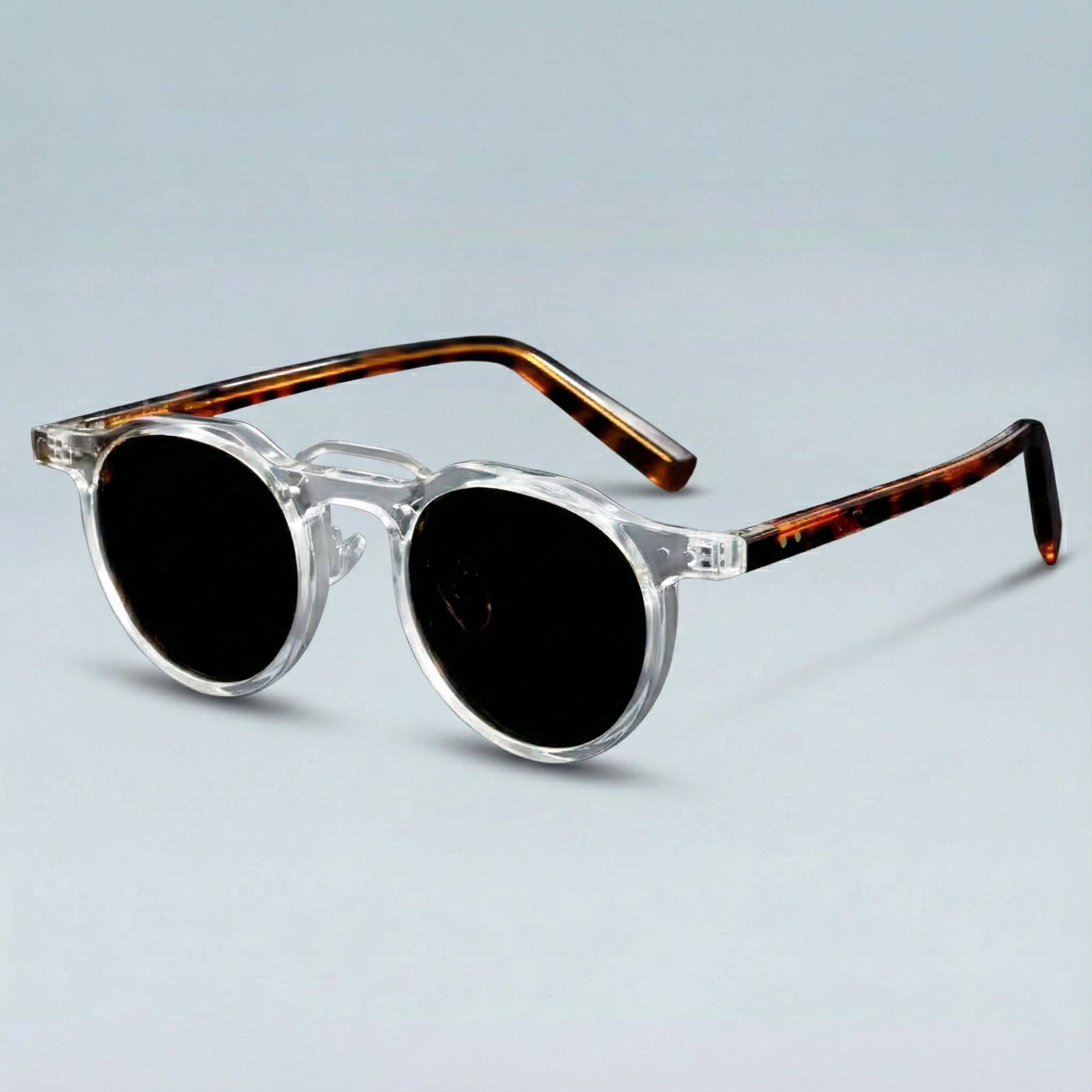 Sunglasses with tortoiseshell frame and clear arms on a light gray background