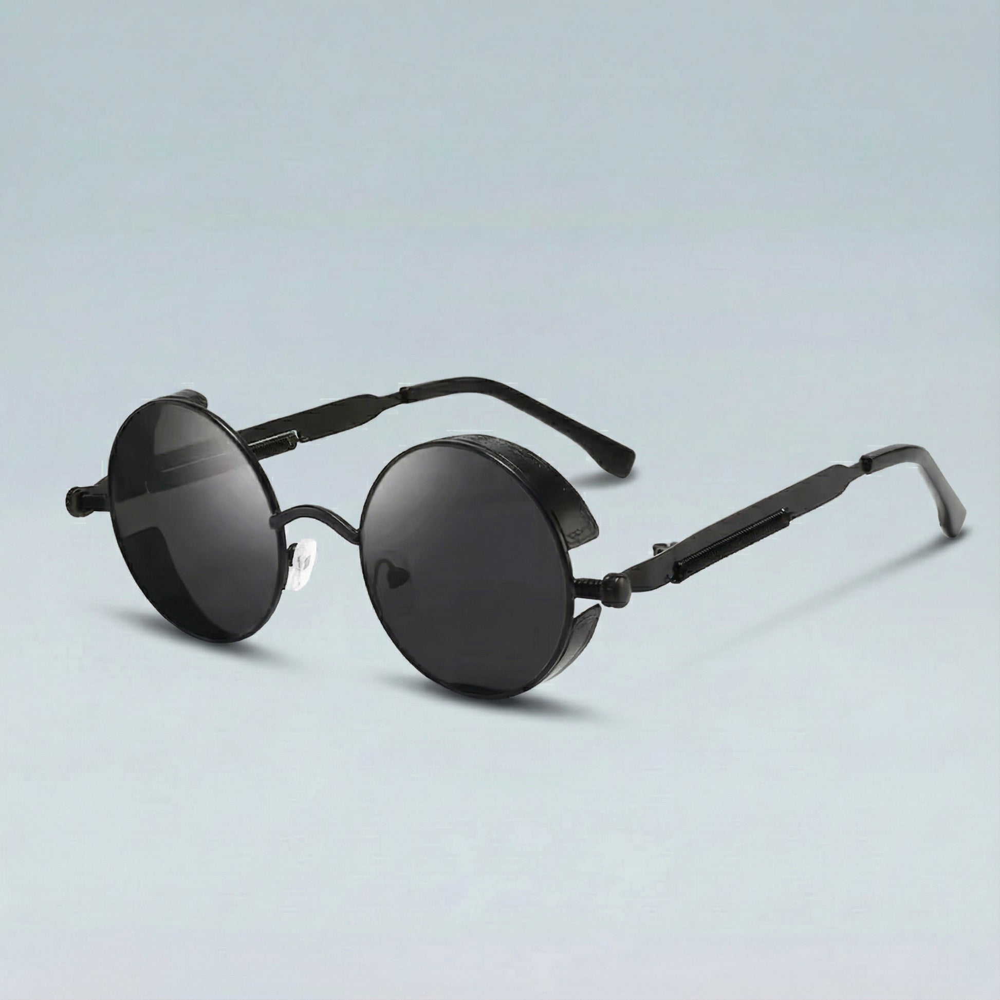 Round black sunglasses with thin frames on a light blue background