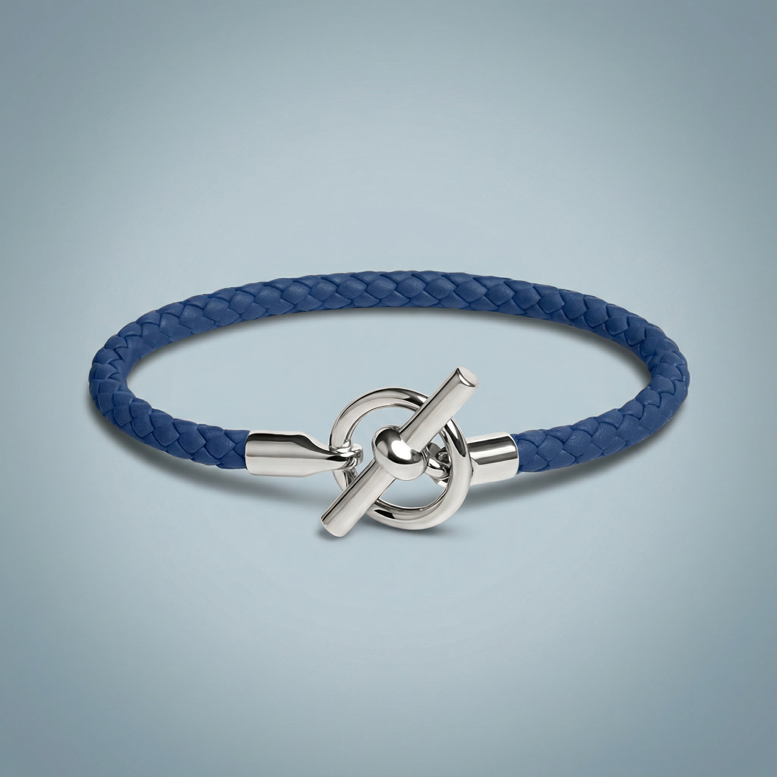 Blue braided bracelet with a silver clasp on a light gray background