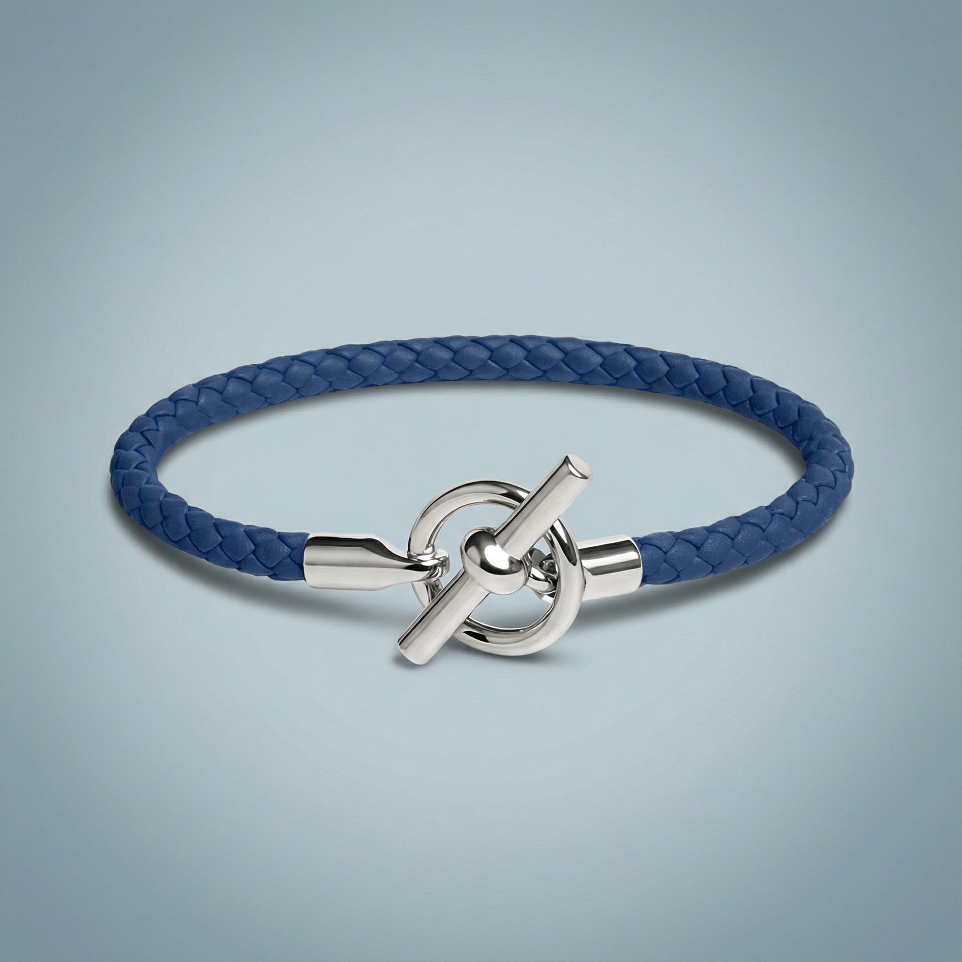 Blue braided bracelet with a silver clasp on a light gray background