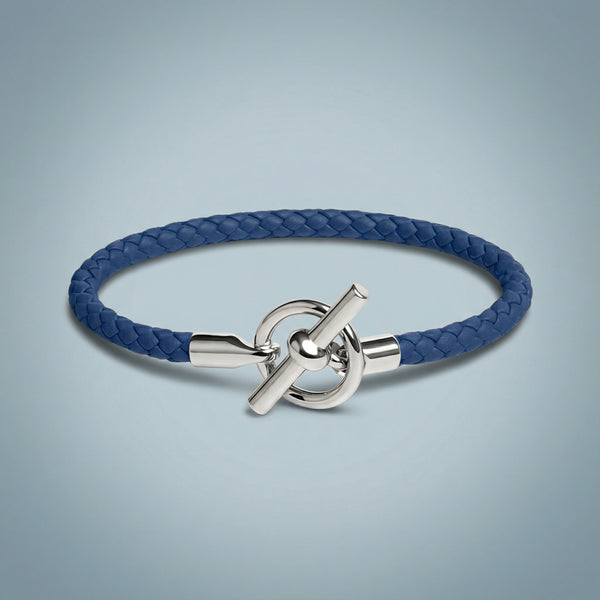 Blue braided bracelet with a silver clasp on a light gray background