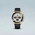 Luxury watch with black strap and rose gold case on light blue background