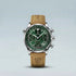 Watch with green face and brown leather strap on light gray background