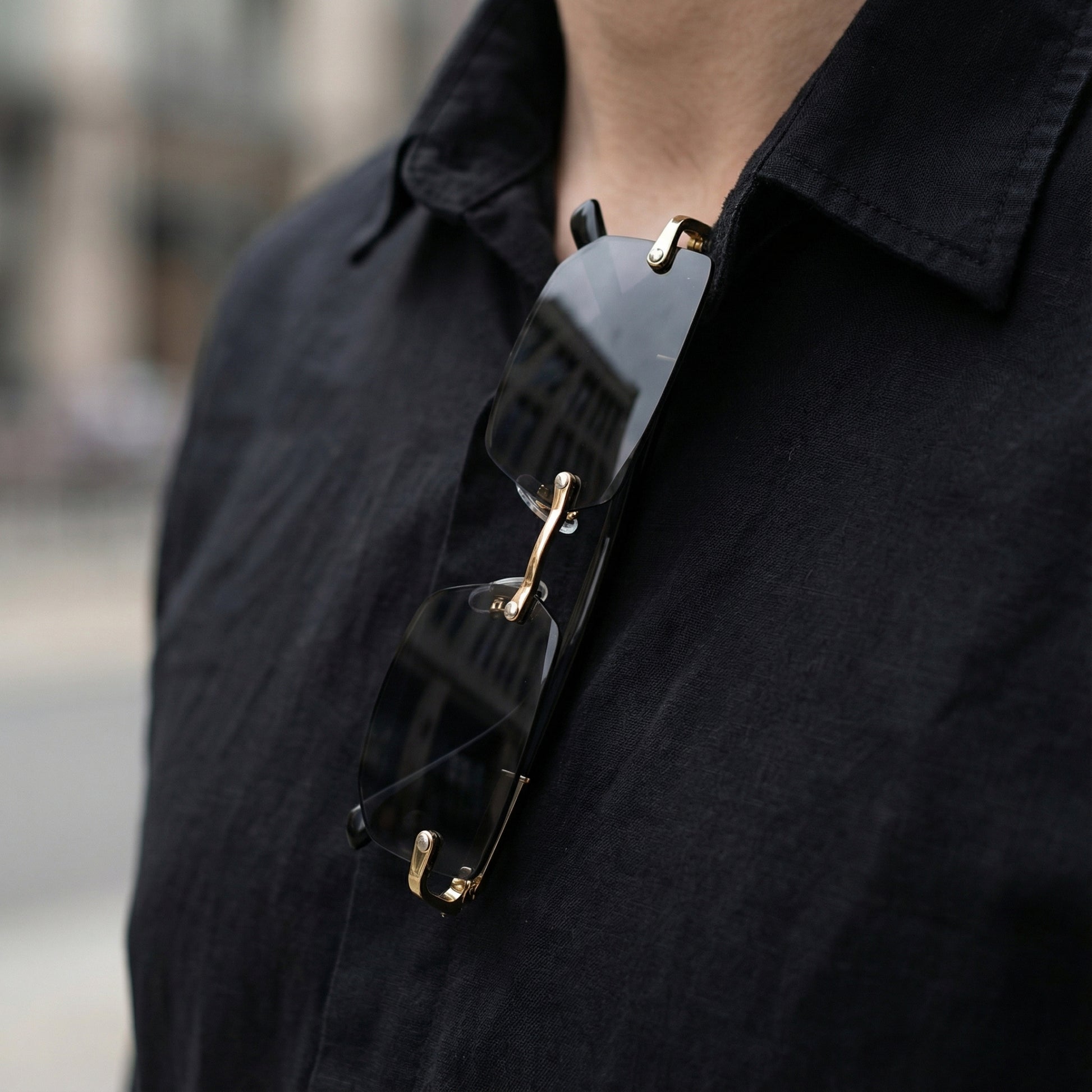Person wearing a black shirt with a unique necklace