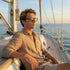 Man wearing sunglasses on a sailboat with ocean view